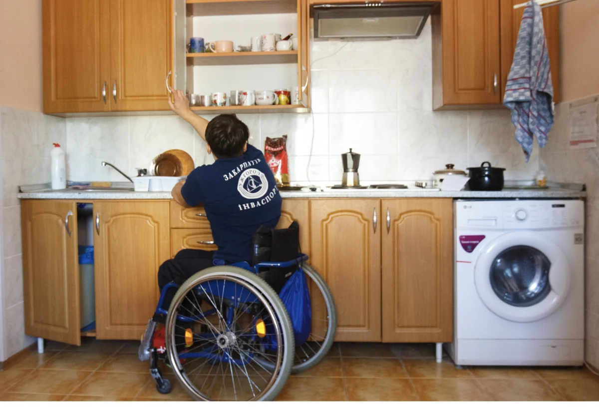 Wheelchair user preparing food in an accessible kitchen